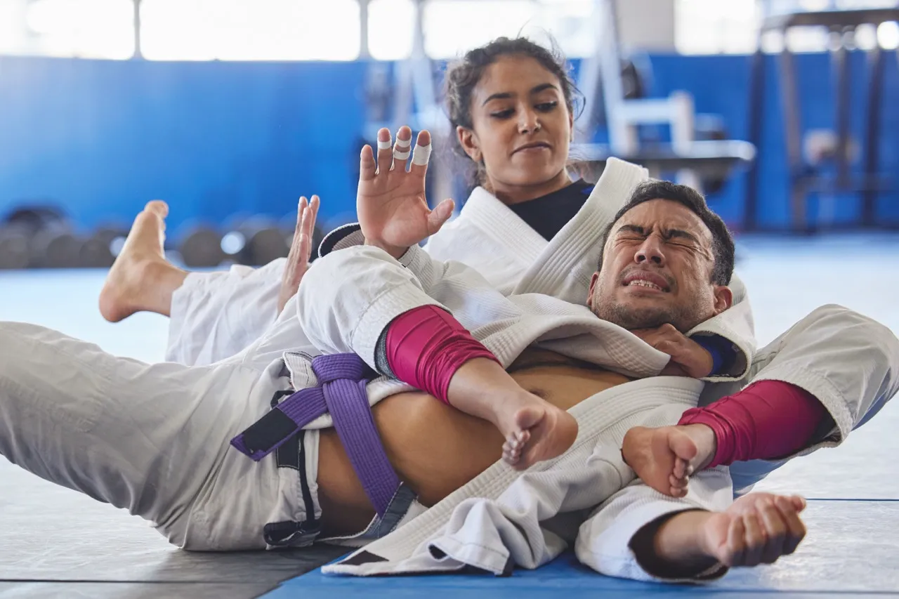 A Ronin BJJ athlete finishing a bow-and-arrow choke from the back during a gi round.